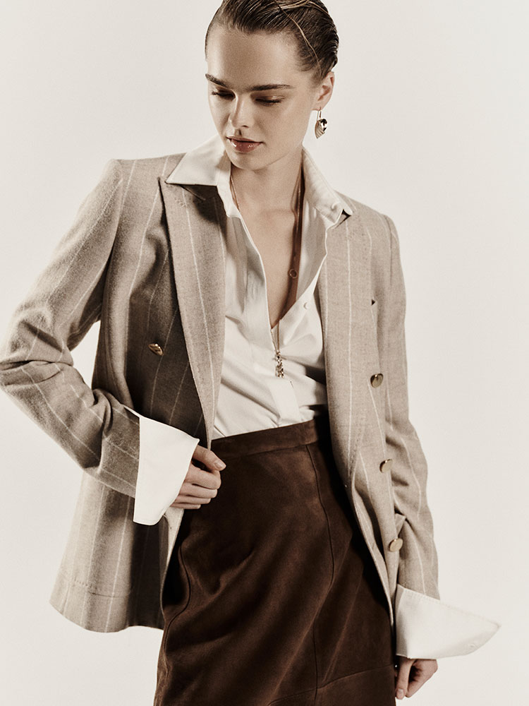 Model trägt den doppelreihigen Blazer von Max Mara Sartoriale in Beige aus Alpaka und Wolle zu heller Bluse und brauner Hose.