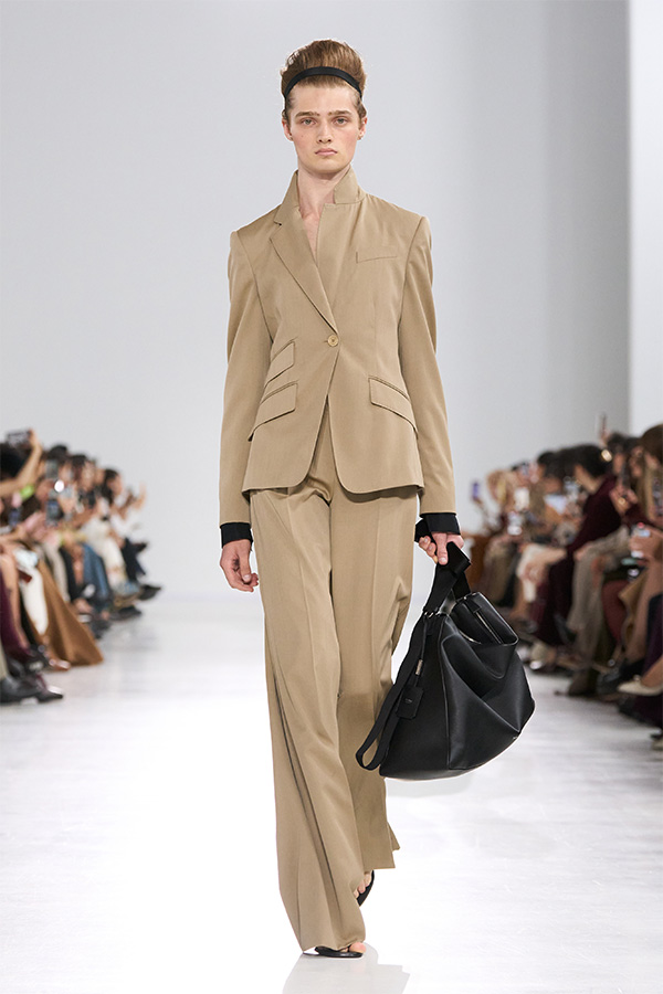 Max-Mara-Show Frühjahr/Sommer 2026 – Look in Beige mit einfarbigem Anzug und Hose mit schwarzer Tasche in der Hand.