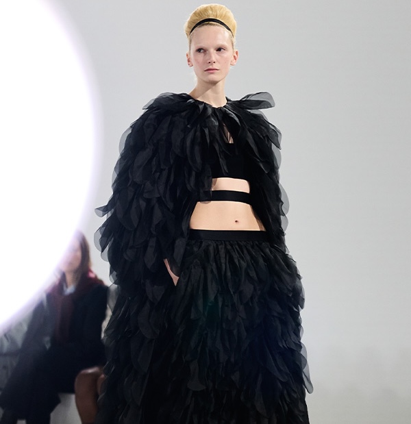 Défilé Max Mara Printemps Été 2026 : vue d’un mannequin sur la passerelle avec look noir veste et jupe avec détails.